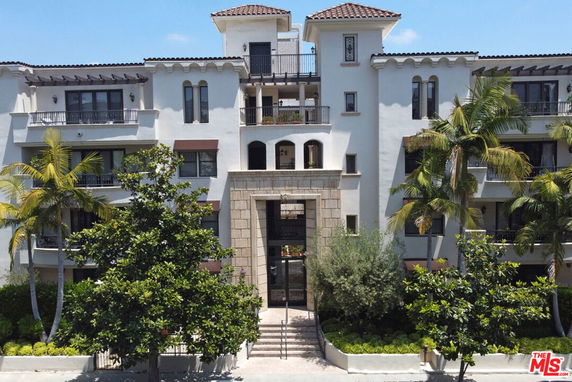 Front view of a multi-story building with balconies and a central entrance.