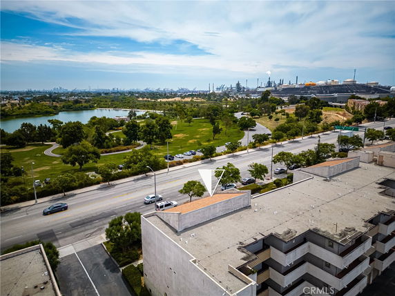 Panoramic view showing buildings and a park area with a lake.