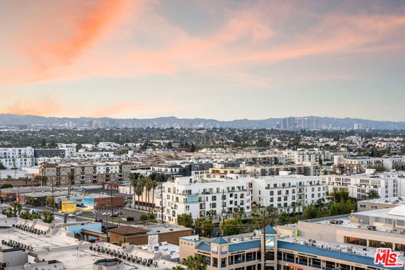 Wide angle view of cityscape with buildings and a distant skyline.