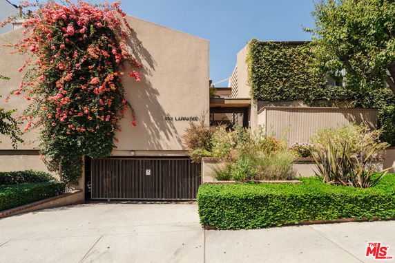 Front view of a house with climbing plants and garage entrance.