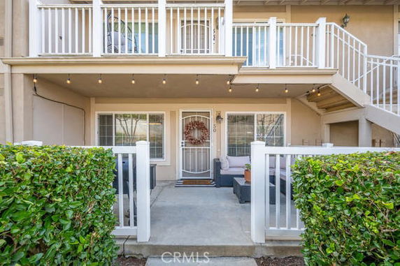 Front view of a house with a patio and balcony.