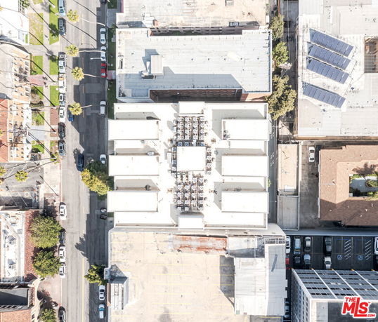Aerial view of a building's rooftop with multiple air conditioning units.