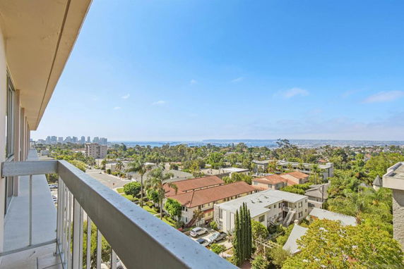 Panoramic view from a building showing surrounding residential area and distant cityscape.