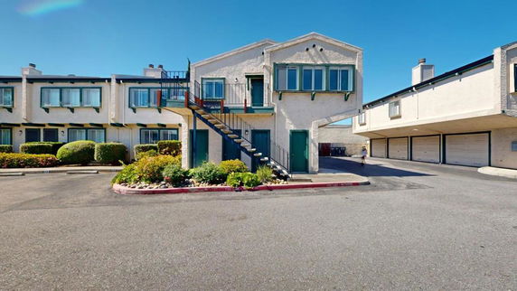 Front view of a two-story apartment building with attached garage.