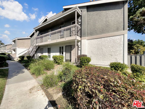 Front view of a two-story apartment building with exterior stairs.