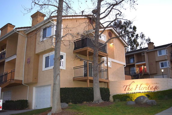 Front view of a multi-story residential building with balconies and garages.
