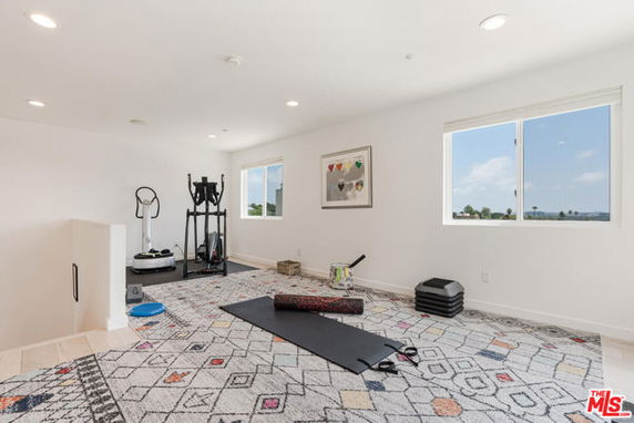 Room with workout equipment and yoga mat inside a house.