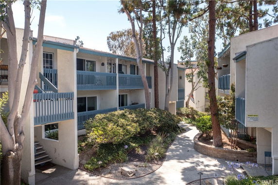 View of a multi-story apartment building with beige walls and blue railings.