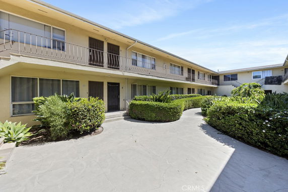 Front view of a two-story apartment building with a central courtyard.