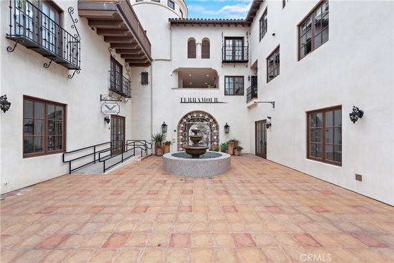 Front view of a multi-story building with a central courtyard and fountain.