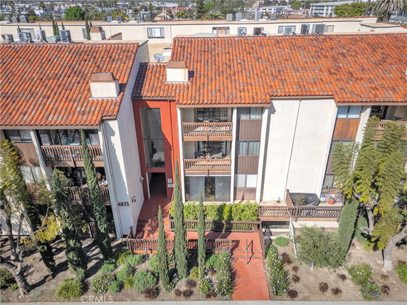 Front view of a multi-story building with tiled roof and balconies.