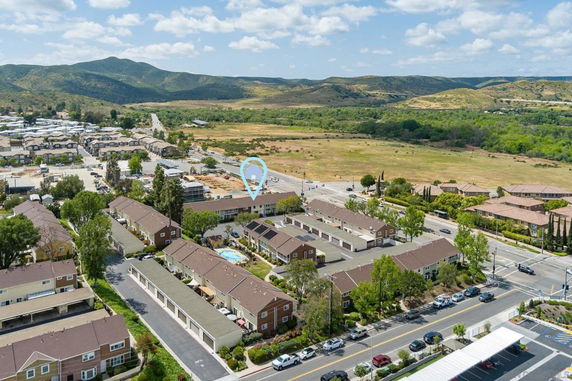 Aerial view of a residential area with rows of houses and surrounding open fields.