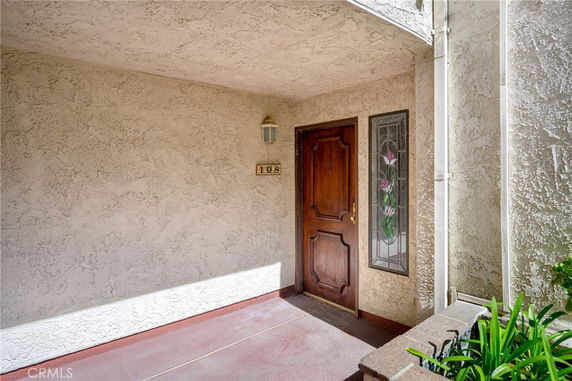 Entrance to a building with a decorative glass panel next to a wooden door.