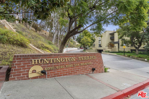 Front view of an entrance to a residential complex with a brick sign reading 'Huntington Terrace'.