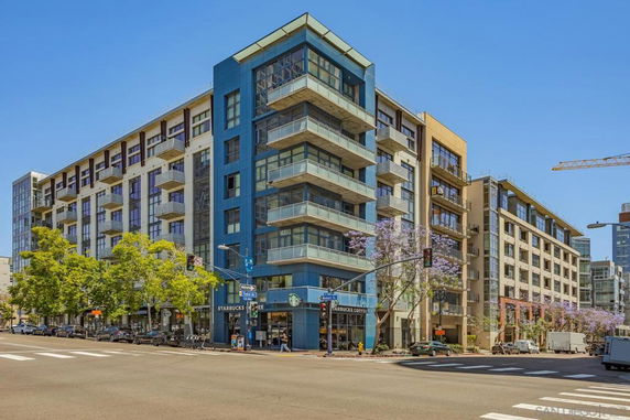 Front view of a multi-story residential and commercial building with balconies.