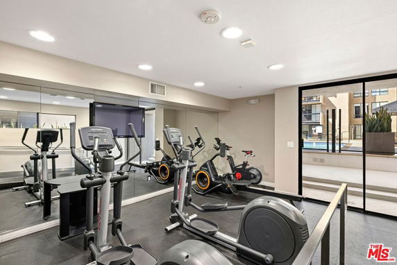 Indoor gym area with exercise equipment and mirrored walls.