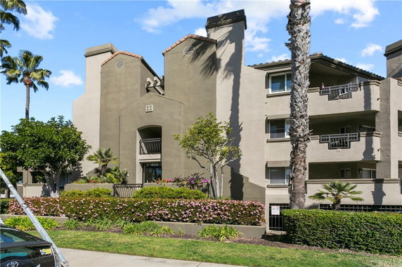 Front view of a multi-story apartment building with balconies.