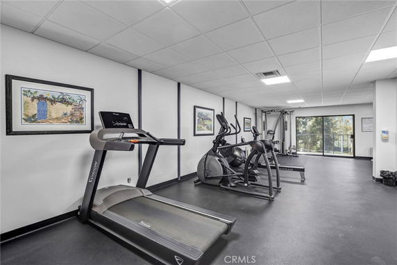 Indoor gym area with fitness equipment including a treadmill and exercise machines.