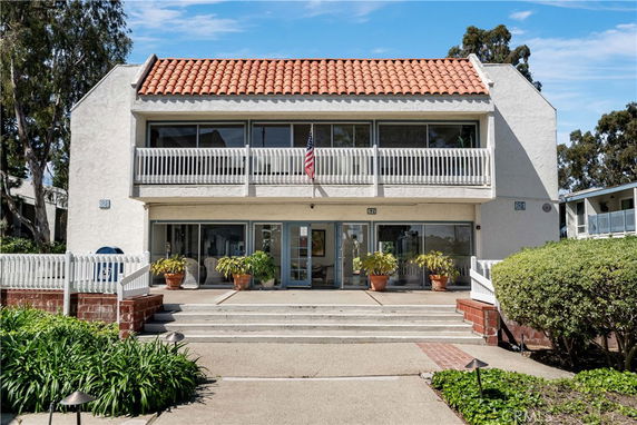 Front view of a two-story building with a tiled roof and balcony.