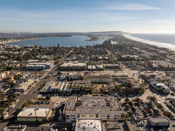 Aerial view of a coastal city with buildings and ocean in the background.