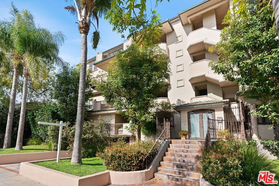 Front view of a multi-story residential building with a gated entrance.