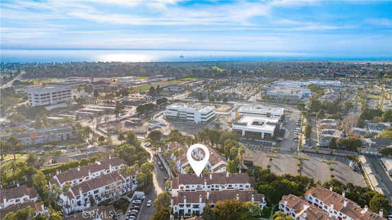 Panoramic view of a residential area with multiple buildings and distant coastline.