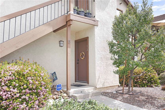 Entrance of a house with an outdoor staircase leading to an upper level.