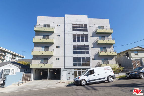 Front view of a multi-story apartment building with balconies.