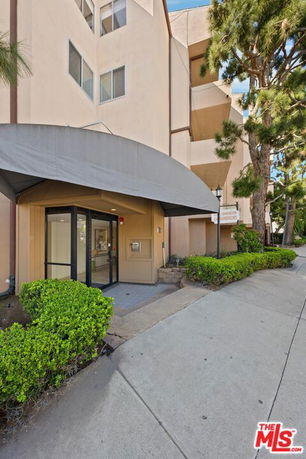 Entrance of a multi-story building with awning and glass doors.