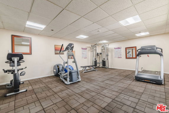 Indoor gym with exercise equipment including a treadmill, elliptical, and exercise bike.