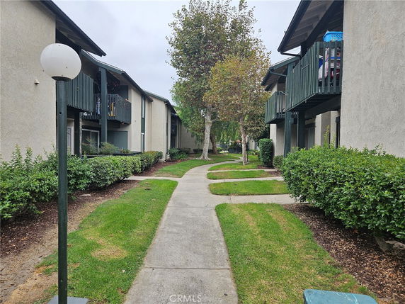 Front view of an apartment complex with green balconies and pathways.