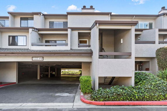 Front view of a multi-story residential building with covered parking.