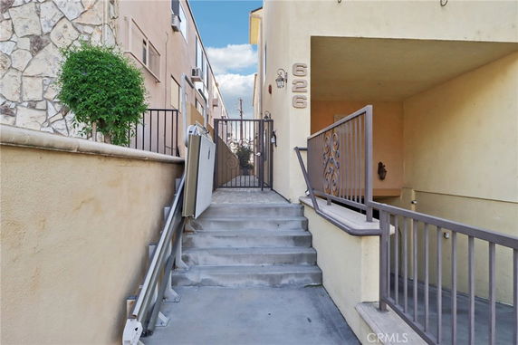 Entrance view with a gated stairway leading to a building entry.