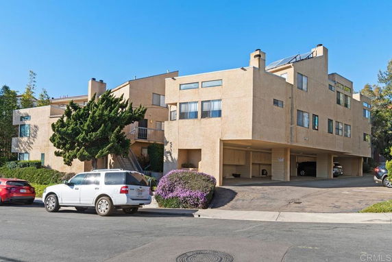 Front view of a multi-story residential building with parking underneath.