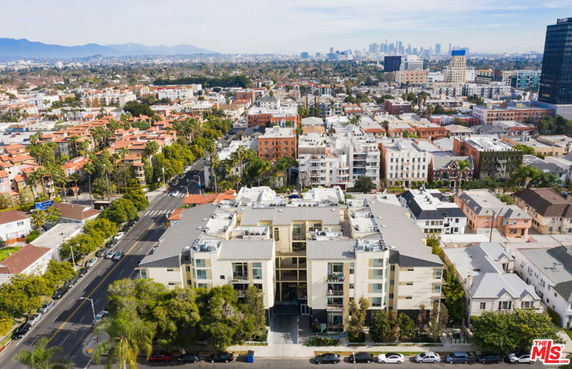 Aerial view of a cityscape with a large building in the foreground.
