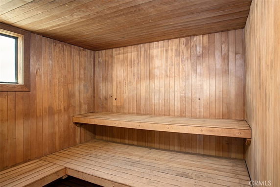 Interior of a wooden sauna room with benches and a window.