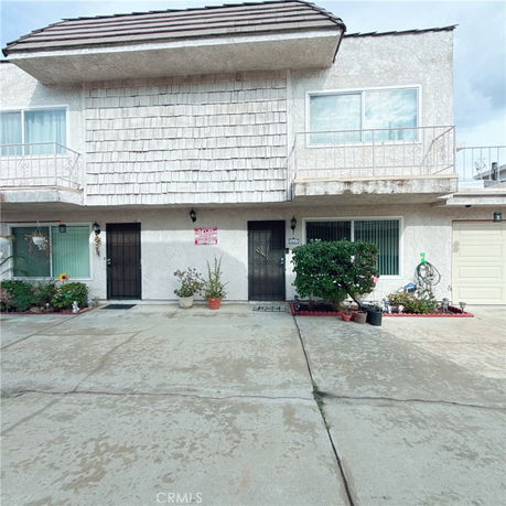 Front view of a two-story residential building with two entrances and balconies.