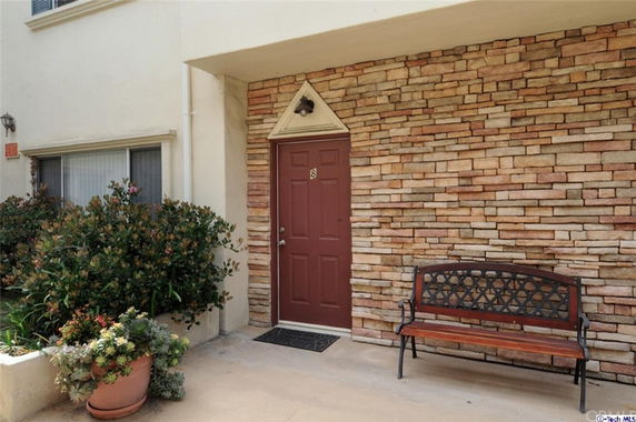 Entrance with a red door and stone wall facade.