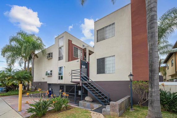 Front view of a multi-story building with an exterior staircase.