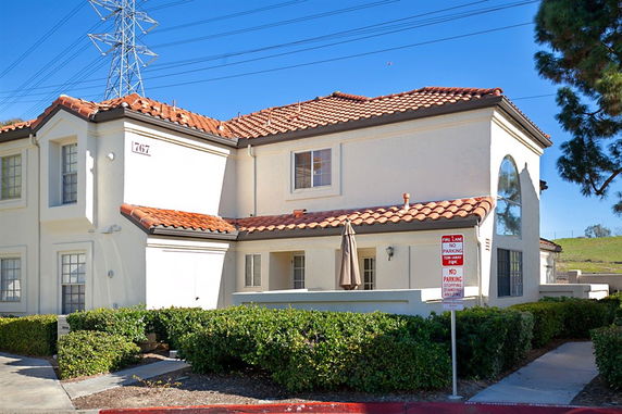 Front view of a two-story house with a red-tiled roof and arched window.