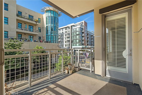 View from the balcony of a building showing adjacent modern buildings with multiple floors.