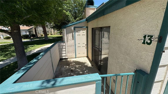 Exterior view of a house with a small patio and a numbered address.