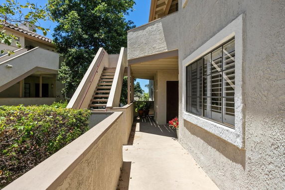 Exterior view with stairs leading to an upper level of an apartment building.
