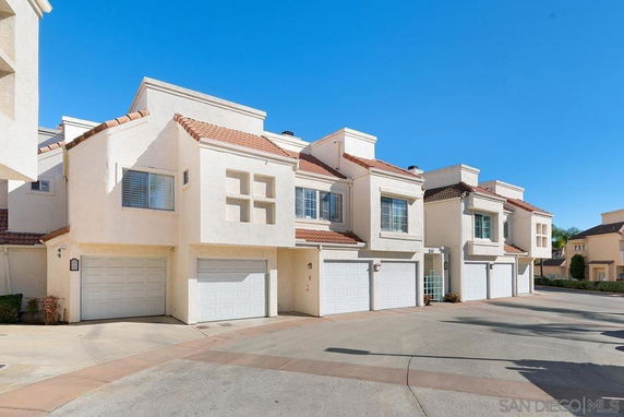 Front view of a row of two-story townhouses with garages.