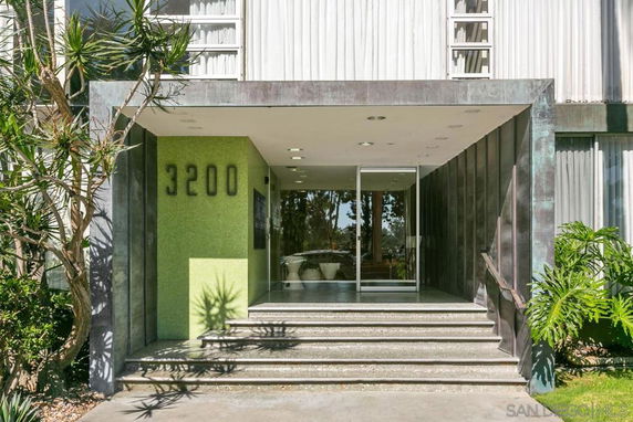 Front view of a modern building entrance with steps and glass doors.