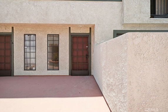 Front view of a building with two doors and narrow windows between them.