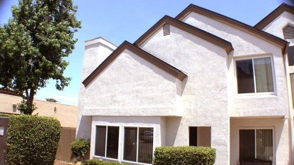 Front view of a multi-story house with prominent triangular roof sections.