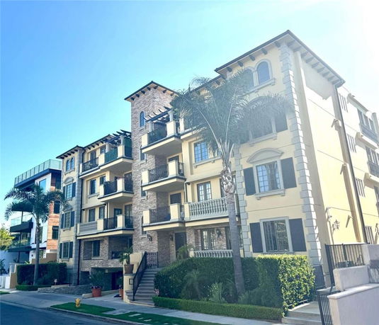Front view of a multi-story residential building with balconies and decorative elements.