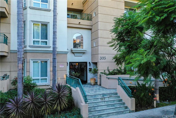 Front view of a multi-story building with stairs leading to the entrance.