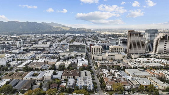 Panoramic cityscape with buildings and distant hills.